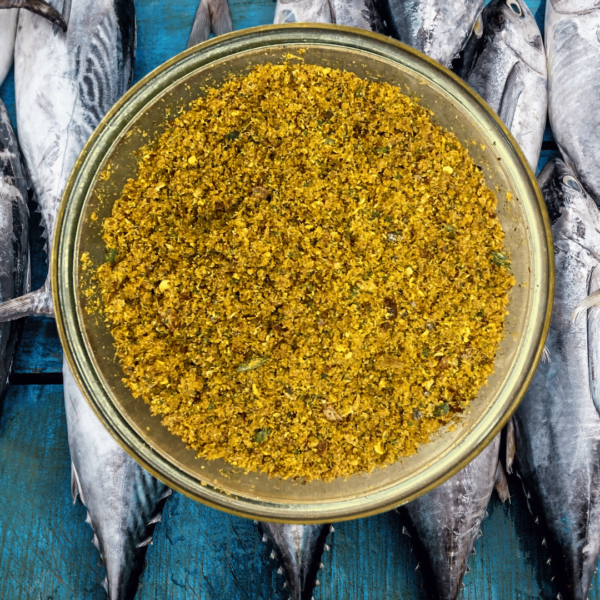 ZestBites dry tuna fish Chutney Powder in a transparent glass bowl in background tuna fishes